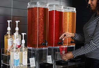 Woman uses Teavana iced tea dispenser Woman uses Teavana iced tea dispenser
