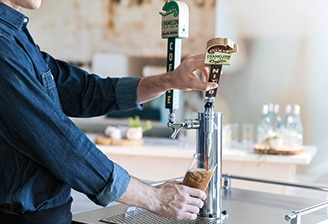 Man pours Chameleon Nitro Cold Brew from tap Man pours Chameleon Nitro Cold Brew from tap