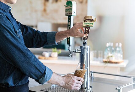 Man pours Chameleon Nitro Cold Brew from tap Man pours Chameleon Nitro Cold Brew from tap