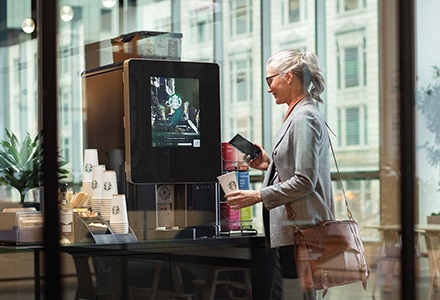 Woman Uses Touchless Starbucks Serenade Brewer in Apartment Common Area Woman Uses Touchless Starbucks Serenade Brewer in Apartment Common Area