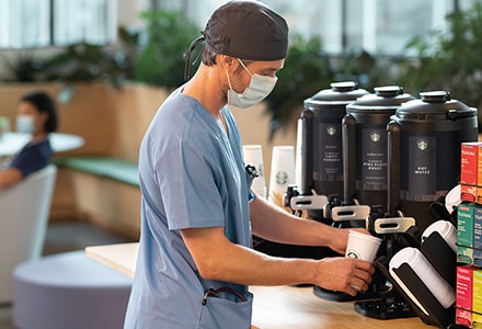 Doctor Pouring Cup of Starbucks Coffee in Hospital Café Doctor Pouring Cup of Starbucks Coffee in Hospital Café