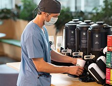 Doctor Pouring Cup of Starbucks Coffee in Hospital Café Doctor Pouring Cup of Starbucks Coffee in Hospital Café