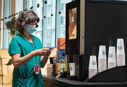 Nurse Using Starbucks Serenade Coffee Machine in Hospital Nurse Using Starbucks Serenade Coffee Machine in Hospital