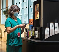 Nurse Using Starbucks Serenade Coffee Machine in Hospital Nurse Using Starbucks Serenade Coffee Machine in Hospital