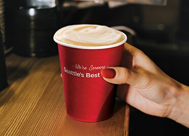 Hand Holding Seattle’s Best Coffee Cup With Specialty Crafted Espresso Hand Holding Seattle’s Best Coffee Cup With Specialty Crafted Espresso